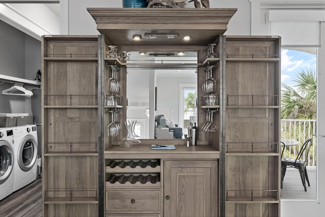 bar with separate washer and dryer and dark hardwood / wood-style flooring