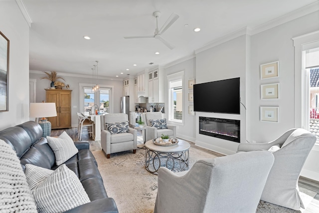 living room with ceiling fan and ornamental molding