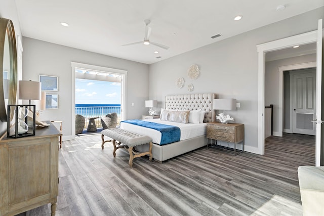 bedroom featuring wood-type flooring, access to outside, ceiling fan, and a water view