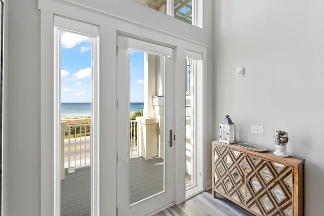 entryway with light wood-type flooring and a water view