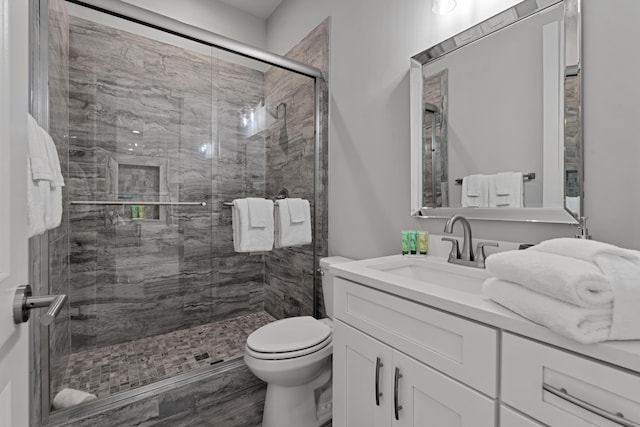 bathroom featuring an enclosed shower, vanity, and toilet