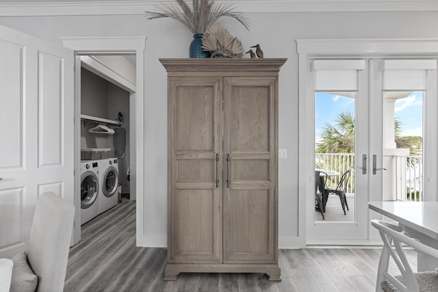 washroom with wood-type flooring, washing machine and dryer, and french doors