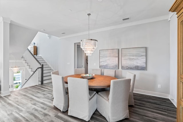 dining room featuring crown molding, dark wood-type flooring, and an inviting chandelier