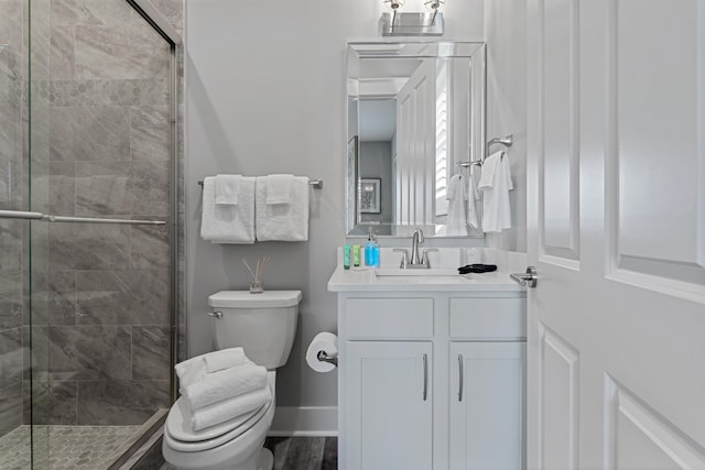 bathroom with an enclosed shower, vanity, wood-type flooring, and toilet