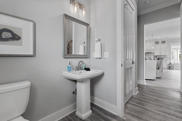 bathroom featuring ornamental molding, wood-type flooring, backsplash, and toilet