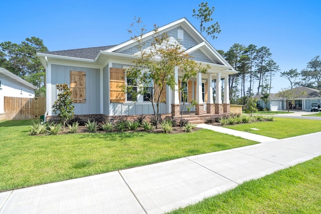 view of front of property featuring a garage, a front yard, and covered porch