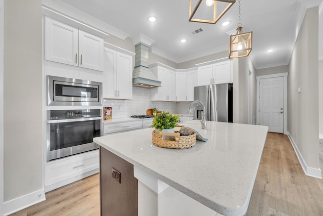 kitchen with visible vents, white cabinets, appliances with stainless steel finishes, crown molding, and backsplash