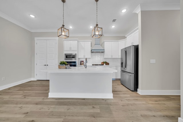 kitchen featuring pendant lighting, stainless steel appliances, an island with sink, and white cabinets