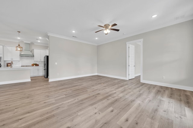 unfurnished living room with baseboards, light wood-style flooring, visible vents, and a ceiling fan