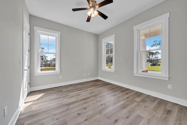 spare room featuring ceiling fan, baseboards, and wood finished floors