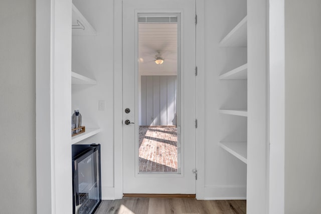 doorway to outside featuring wine cooler, hardwood / wood-style floors, and built in features