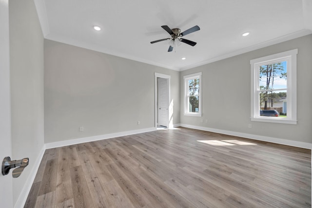 spare room featuring baseboards, wood finished floors, and ornamental molding