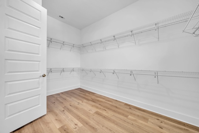 walk in closet with light wood-style floors