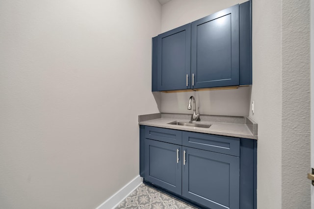 bar featuring blue cabinets and sink