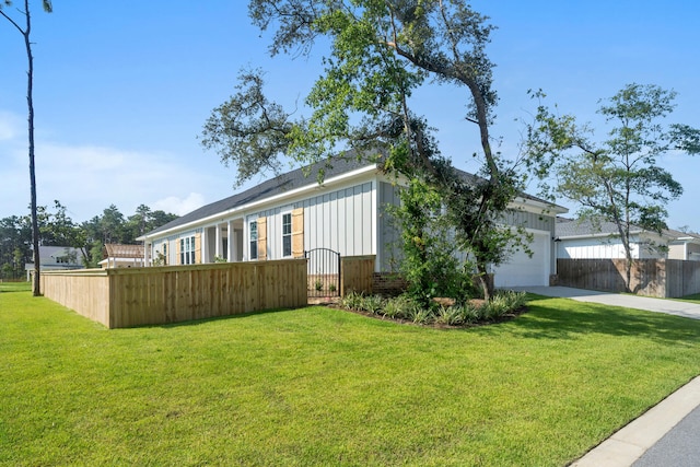 view of front of property with a yard, an attached garage, board and batten siding, fence, and driveway