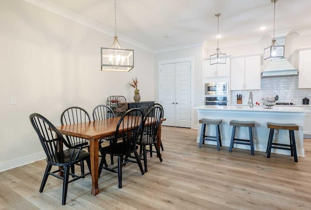 dining space featuring baseboards, ornamental molding, and light wood-style floors