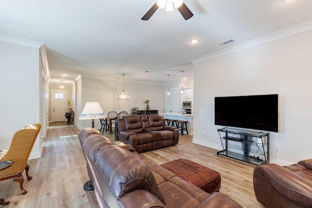 living room with ornamental molding, ceiling fan, and light wood-type flooring