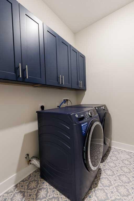 clothes washing area with cabinets and independent washer and dryer