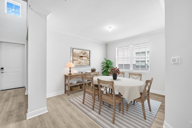 dining area with crown molding and light hardwood / wood-style flooring