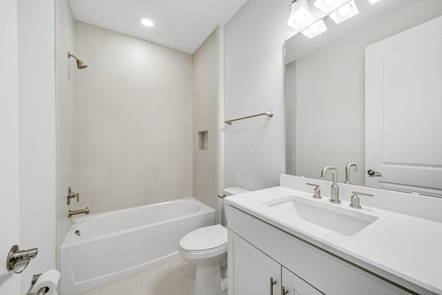 full bathroom featuring tile patterned flooring, vanity, tiled shower / bath combo, and toilet