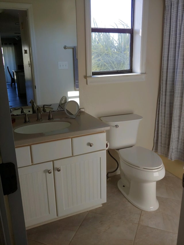 bathroom featuring vanity, tile patterned floors, and toilet