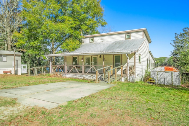 rear view of house with covered porch and a lawn