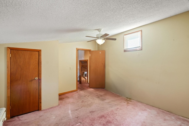 unfurnished room with ceiling fan, vaulted ceiling, and a textured ceiling