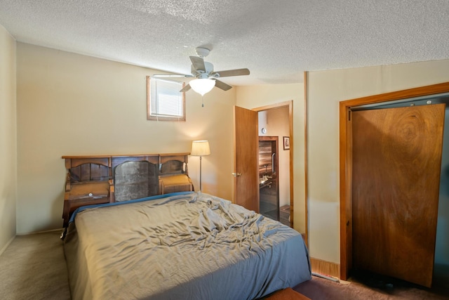 bedroom featuring ceiling fan, a textured ceiling, and dark colored carpet