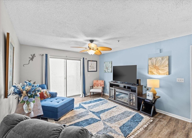 living room featuring hardwood / wood-style floors, a textured ceiling, and ceiling fan