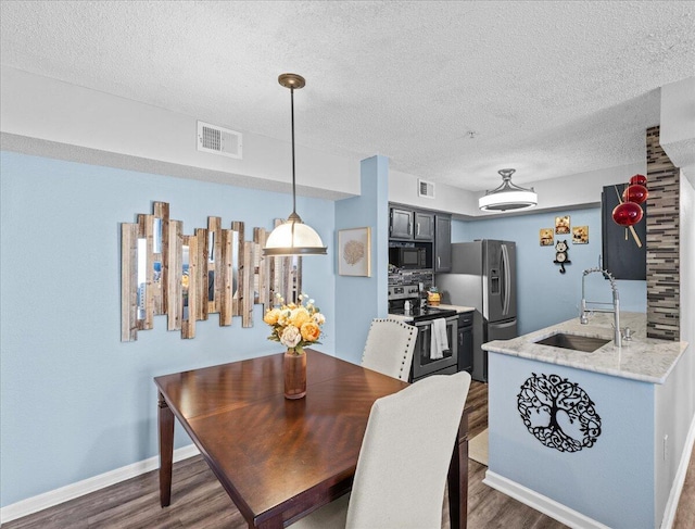 dining room with dark hardwood / wood-style floors, sink, and a textured ceiling