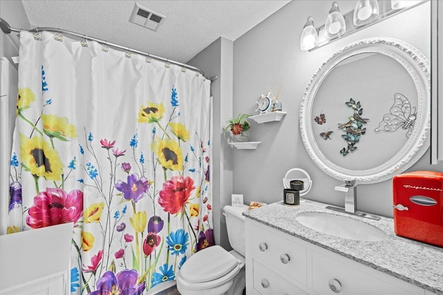 bathroom featuring vanity, toilet, curtained shower, and a textured ceiling