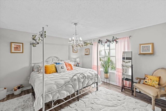 bedroom with wood-type flooring, a chandelier, and a textured ceiling