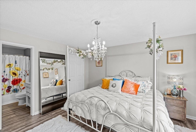 bedroom with an inviting chandelier, dark hardwood / wood-style floors, and a textured ceiling