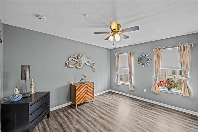 interior space featuring ceiling fan, dark hardwood / wood-style floors, and a textured ceiling