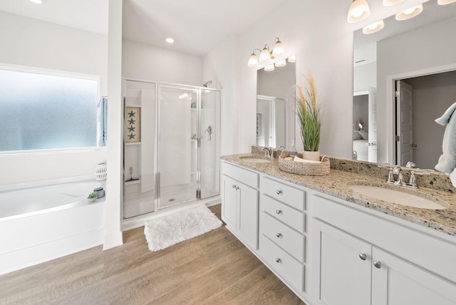 bathroom with independent shower and bath, wood-type flooring, and vanity