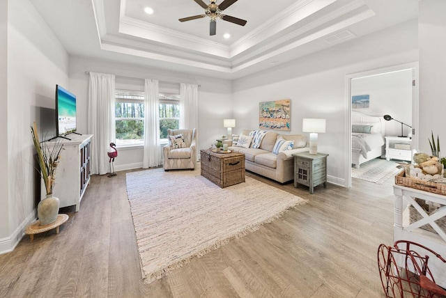 bedroom featuring ceiling fan, ornamental molding, a raised ceiling, and hardwood / wood-style floors