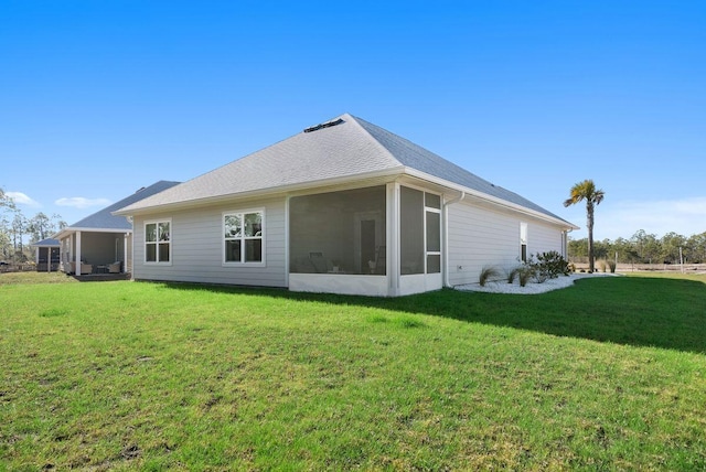 rear view of property featuring a sunroom and a yard