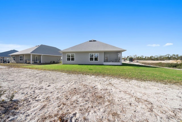 rear view of house with a sunroom and a yard