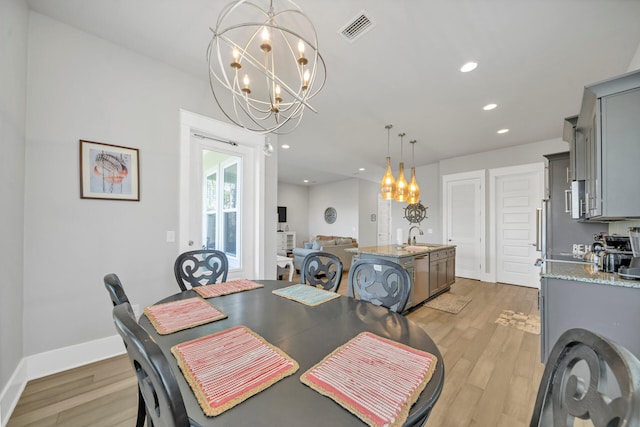 dining space featuring a chandelier and light wood-type flooring