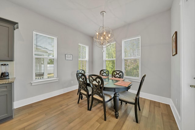 dining space featuring an inviting chandelier and light hardwood / wood-style flooring