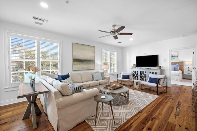 living room with dark wood-type flooring and ceiling fan