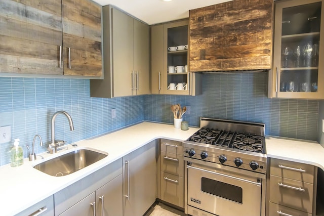 kitchen featuring gray cabinets, sink, luxury stove, and backsplash