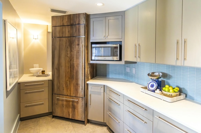 kitchen with gray cabinetry, backsplash, and light tile patterned floors