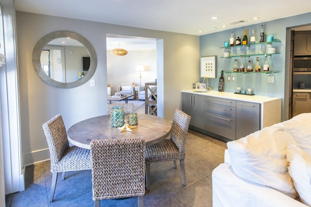 dining room with indoor wet bar and tile patterned floors