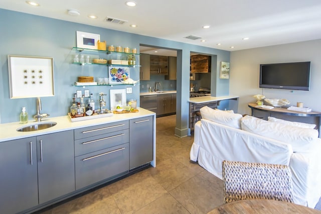 bar with gray cabinets, tile patterned flooring, sink, and stainless steel dishwasher