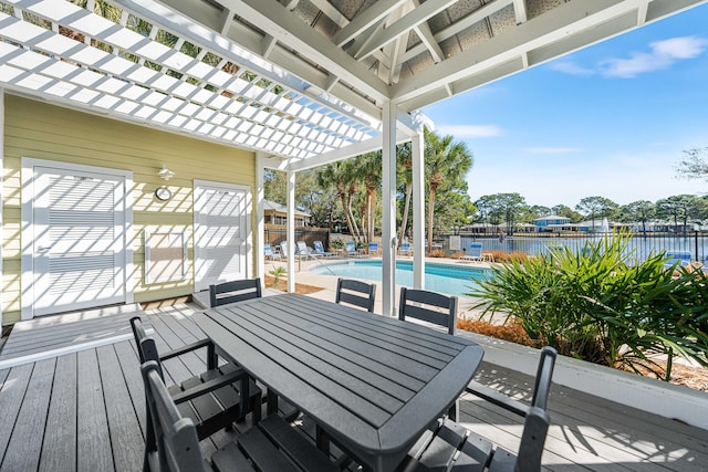 wooden terrace with a fenced in pool, a pergola, and a water view