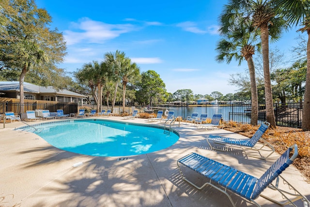 view of swimming pool with a patio and a water view