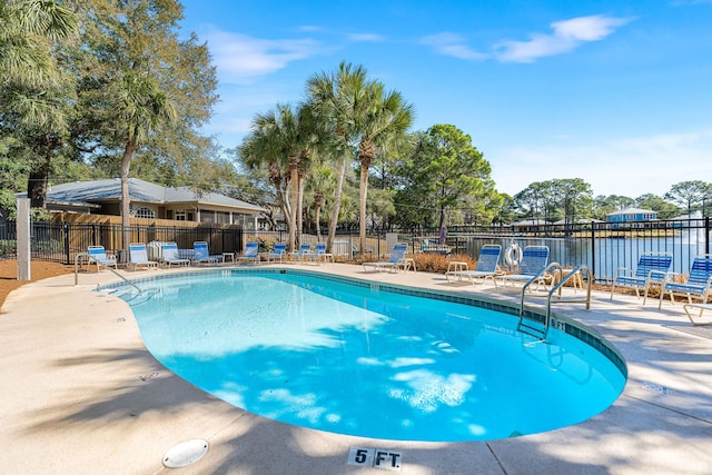 view of pool with a patio and a water view