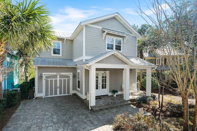 rear view of property featuring a garage and french doors