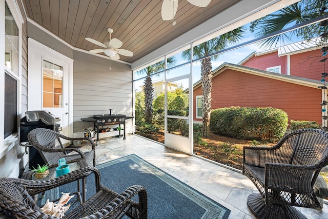 sunroom featuring wood ceiling and ceiling fan